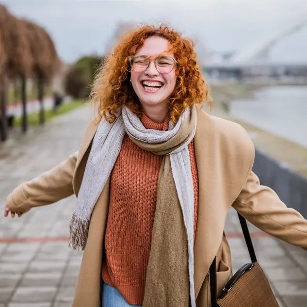 Una paziente cammina sorridendo, a braccia aperte
